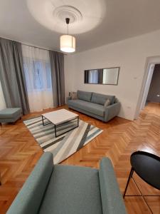 ein Wohnzimmer mit einem Sofa und einem Tisch in der Unterkunft Dalmatinska apartment in Belgrad
