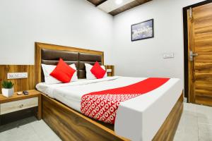 een slaapkamer met een groot bed met rode kussens bij Flagship Hotel Crown in Ludhiana