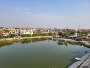 ein großer Wasserkörper mit einer Stadt im Hintergrund in der Unterkunft Anjani Suite in Janakpur