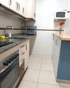 a kitchen with white cabinets and a sink at Apartamento Gerimar - Gelida/Bcn in Gélida