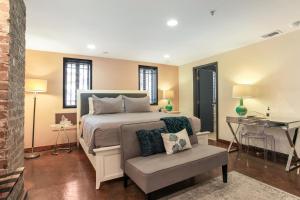 1 dormitorio con 1 cama con silla y escritorio en Canal Street Inn, en Nueva Orleans