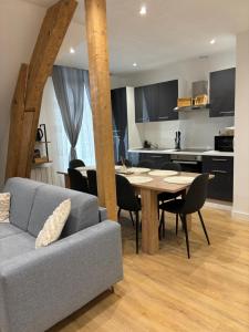 uma sala de estar e cozinha com uma mesa e um sofá em Charmant Appt Duplex - 8 Personnes em Saint-Nectaire