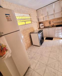 uma cozinha com frigorífico e piso em azulejo em Casa Praia Grande - Arraial do Cabo em Arraial do Cabo