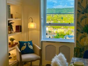 een woonkamer met een stoel en een raam bij The Paragon Penthouse - Stunning Views over Bath! in Bath