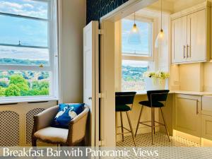 a kitchen with a breakfast bar with panoramic windows at The Paragon Penthouse - Stunning Views over Bath! in Bath