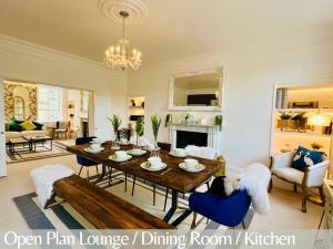 sala de estar de planta abierta con mesa de madera y sillas azules en The Paragon Penthouse - Stunning Views over Bath!, en Bath