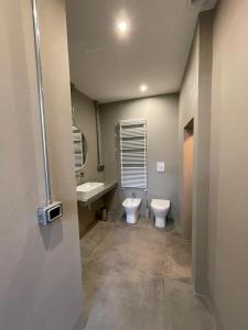 a bathroom with a toilet and a sink and a mirror at TRETRE in Bologna