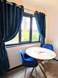 a table and chairs in a room with a window at Magpie 6 HuntersMoon-Warminster-longleat-Bath in Warminster