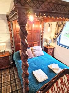 sypialnia z niebieskim łóżkiem z drewnianym baldachimem w obiekcie Magpie 6 HuntersMoon-Warminster-longleat-Bath w mieście Warminster