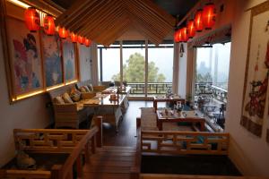 um restaurante com mesas e cadeiras de madeira e janelas grandes em The Wild Sakura em Mukteswar