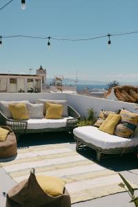 a patio with couches and pillows on a roof at Hostal Africa in Tarifa