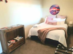 una camera da letto con un letto e uno specchio a parete di Vauxhall Private Suite a Dunedin