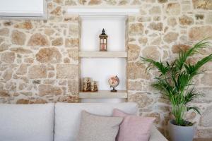 a living room with a stone wall and a white couch at Villa Valentina, Roumeli in Roumelí