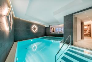 - une grande piscine d'eau bleue dans une maison dans l'établissement A Casa Saphir Appartement-Hotel, à Sölden