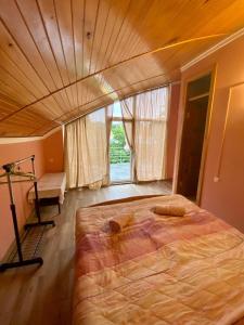 a large bed in a bedroom with a wooden ceiling at Green Hotel Ureki in Ureki