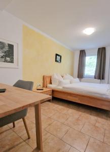 a bedroom with two beds and a desk and a table at Märchenwald Altenberg B&B Hotel in Odenthal