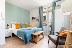 a bedroom with a bed and a table and a chair at Lodging Apartments Barceloneta Beach Studio 31 in Barcelona
