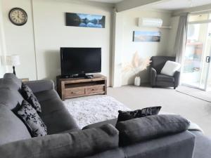 un soggiorno con divano e TV a schermo piatto di Vauxhall Private Suite a Dunedin