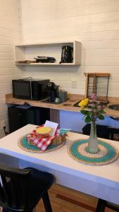 una cocina con una mesa con un jarrón de flores. en Ausruhen Platz - Nova Petrópolis en Nova Petrópolis