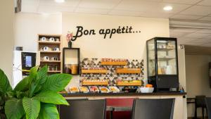 un café avec un comptoir avec des chaises et un panneau indiquant bon appétit dans l'établissement FastHotel Montpellier Ouest - Un Hôtel FH Classic, à Saint-Jean-de-Védas