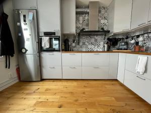 a kitchen with white cabinets and a stainless steel refrigerator at Turnus? Leilighet nær Ahus til leie in Lorenskog