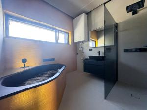 ein Badezimmer mit einer großen Badewanne und einem Waschbecken in der Unterkunft LUXUS-PENTHOUSE mit Weitblick über Graz in Graz