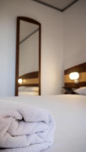 a white towel sitting on a bed in front of a mirror at FastHotel Montpellier Ouest - Un Hôtel FH Classic in Saint-Jean-de-Védas