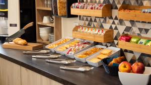 a kitchen counter with several trays of food on it at FastHotel Montpellier Ouest - Un Hôtel FH Classic in Saint-Jean-de-Védas