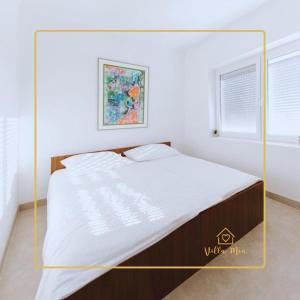 Bett in einem weißen Zimmer mit gelbem Rahmen in der Unterkunft Villa Mia in Prnjavor