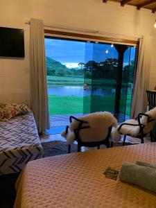 a bedroom with two beds and a large window at Ausruhen Platz - Nova Petrópolis in Nova Petrópolis