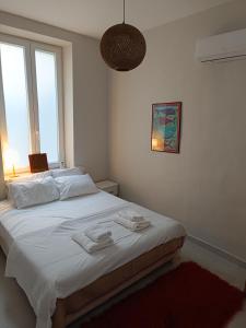 ein Schlafzimmer mit einem Bett, auf dem zwei Handtücher liegen in der Unterkunft flora's memories appartment in Kavala