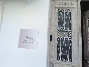 een deur met een bord waarop staat dat architecten welkom zijn bij flora's memories appartment in Kavala