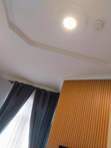 a ceiling with a light and a window with curtains at MUSAROQ HOTEL in Lagos