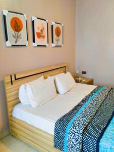 um quarto com uma cama com quatro fotografias na parede em MUSAROQ HOTEL em Lagos