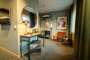 a room with a desk and a mirror and a chair at Spar Hotel Gårda in Gothenburg +129 photos