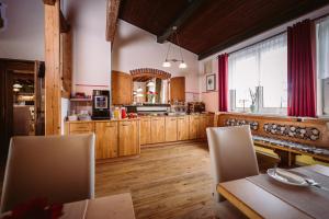 una cocina con armarios de madera y una mesa con sillas. en Pension Baumgartner-Berghof, en Obernberg am Inn