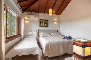 een slaapkamer met 2 bedden en een raam bij Paraíso Buziano 2 in Búzios
