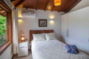 Un pat sau paturi într-o cameră la Paraíso Buziano 2