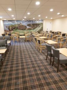 a room with tables and chairs and a large mural at Britannia Hotel Aberdeen in Aberdeen