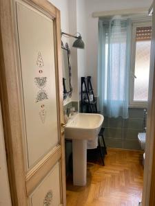 ein Badezimmer mit einem Waschbecken, einem Spiegel und einer Tür in der Unterkunft The Green Loft in Rom