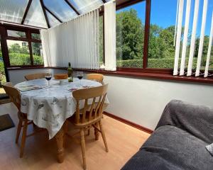 ein Esszimmer mit einem Tisch und Gläsern Wein in der Unterkunft Old Stable Cottage Nanternis in Llanllwchaiarn