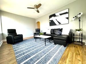 sala de estar con muebles negros y alfombra azul en Modern Cozy walk up with King Bed, en Wilmington