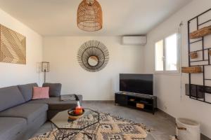uma sala de estar com um sofá e uma televisão em Chez Morgane - Superbe maison familiale proche des remparts em Aigues-Mortes