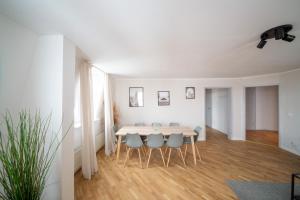 a white dining room with a table and chairs at SweetHome - super Zentral, geräumig und modern in Halle an der Saale