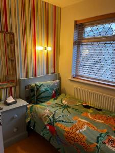 Spacious 4-Bed Haven - Free Parking & Wi-Fi في وايتفيلد: غرفة نوم مع سرير وملاءات نمرية