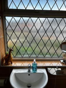 a bathroom sink in front of a window at Spacious 4-Bed Haven - Free Parking & Wi-Fi in Whitefield