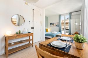 a dining room and living room with a table and chairs at Lodging Apartments Beach Studio 41 in Barcelona