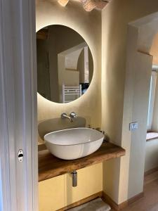 uma casa de banho com um lavatório branco e um espelho. em Domus Eleiva Relais em Suvereto