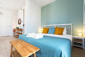 1 dormitorio con cama azul y mesa de madera en Lodging Apartments Beach Studio 41 en Barcelona