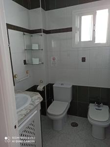 uma casa de banho com um WC e um lavatório em apartamento em Conil de la Frontera